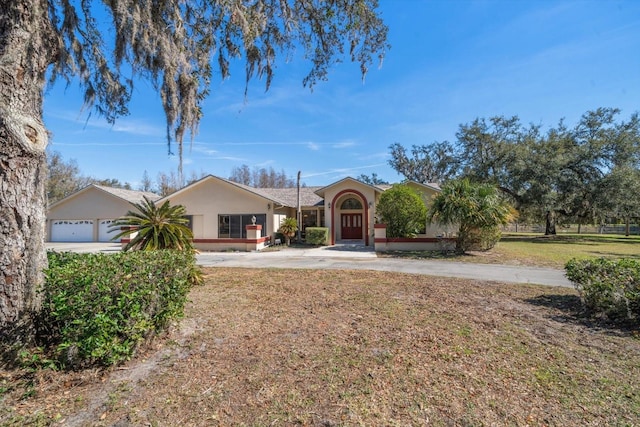 ranch-style home featuring a garage and a front lawn