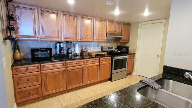 kitchen with dark stone countertops, sink, tasteful backsplash, and stainless steel range with electric cooktop