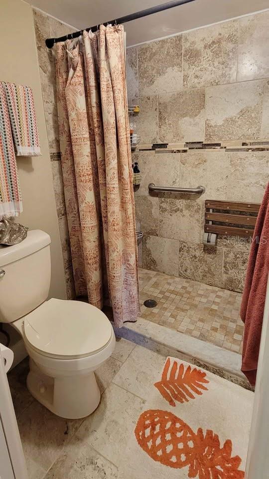 bathroom featuring walk in shower and toilet