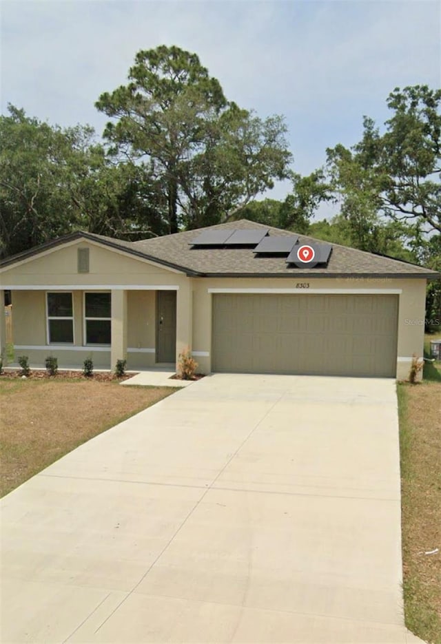 view of front of property with a garage and solar panels