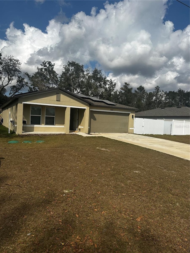 view of front of property featuring a garage, solar panels, and a front lawn