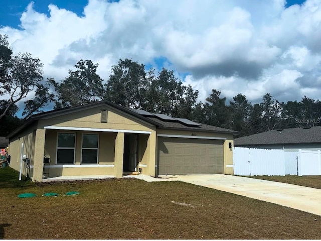 view of front of home featuring a garage, a front lawn, and solar panels