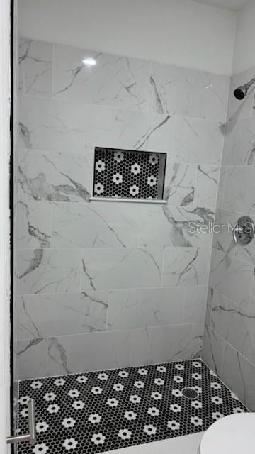 bathroom with tiled shower and toilet