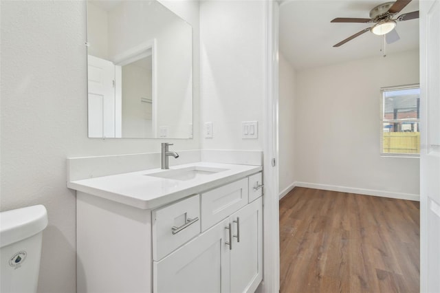 bathroom featuring hardwood / wood-style flooring, ceiling fan, vanity, and toilet