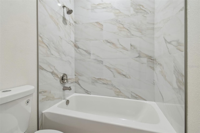 bathroom featuring tiled shower / bath and toilet