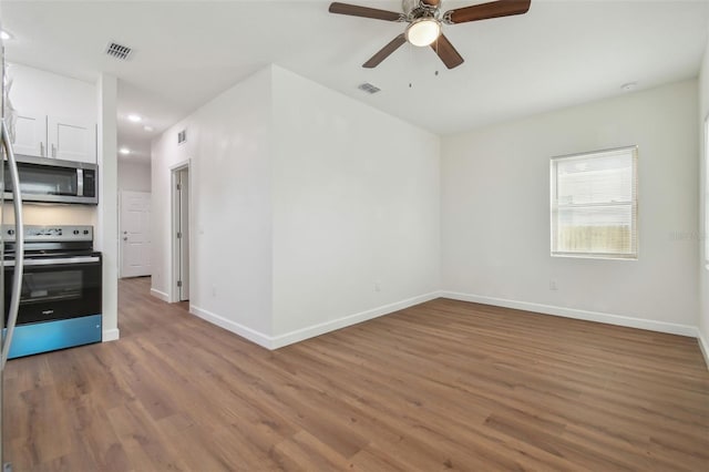 spare room with hardwood / wood-style floors and ceiling fan