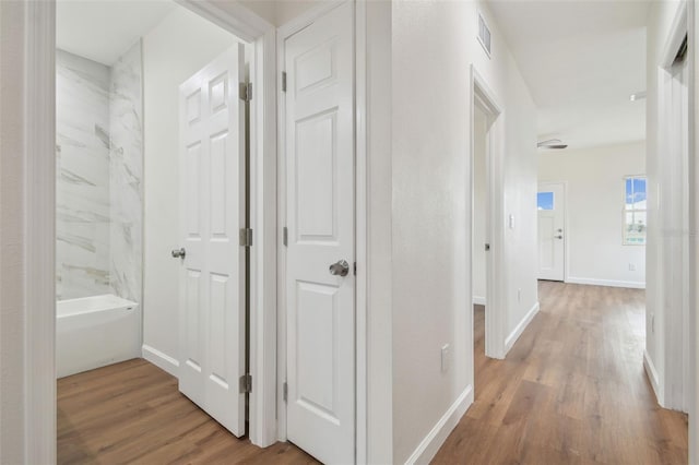 corridor with hardwood / wood-style flooring