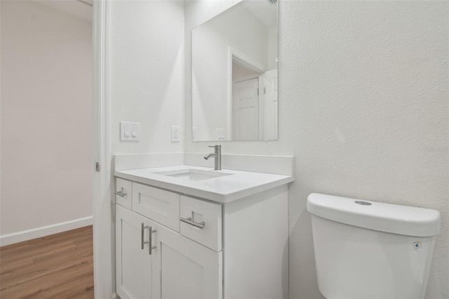 bathroom featuring vanity, hardwood / wood-style floors, and toilet