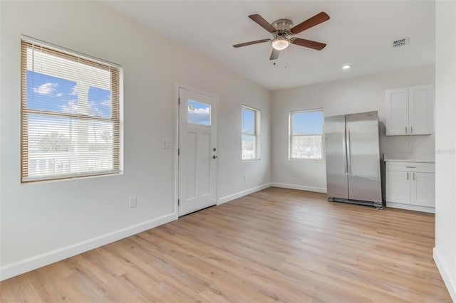 entryway with ceiling fan, plenty of natural light, and light hardwood / wood-style flooring