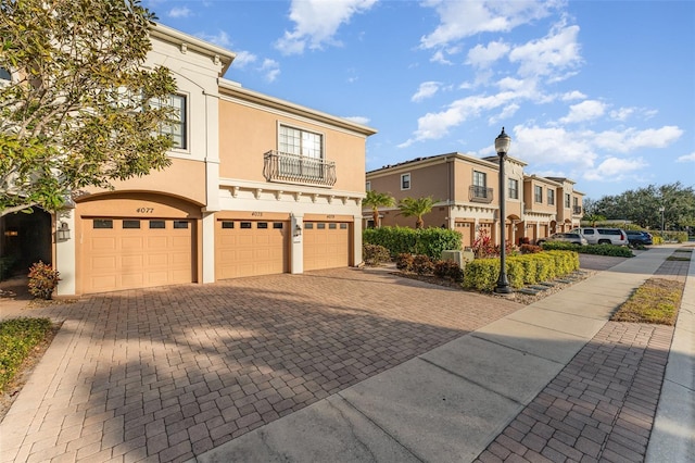 view of front of property featuring a garage and a balcony