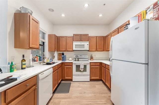 kitchen with sink, white appliances, and light wood-type flooring