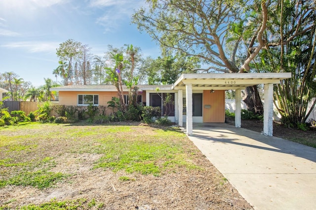 ranch-style house with a front yard and a carport