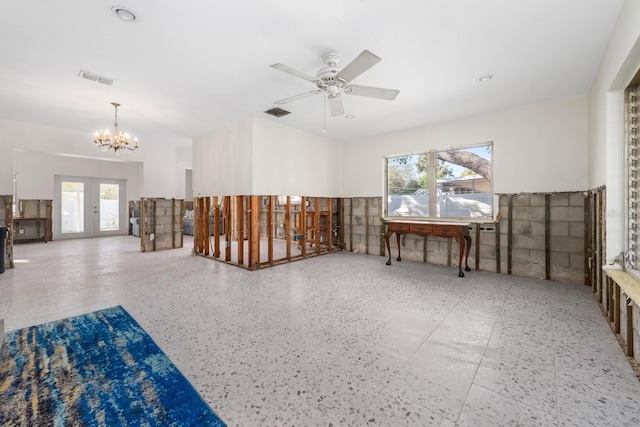 spare room with ceiling fan with notable chandelier and french doors