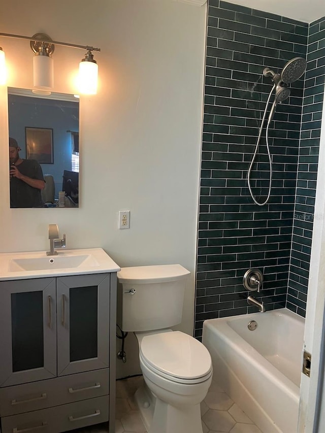 full bathroom featuring vanity, tile patterned floors, toilet, and tiled shower / bath