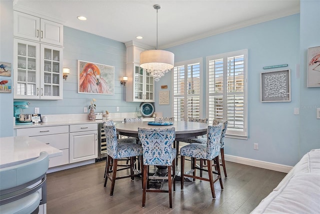 dining space featuring ornamental molding, dark wood-type flooring, beverage cooler, and a chandelier