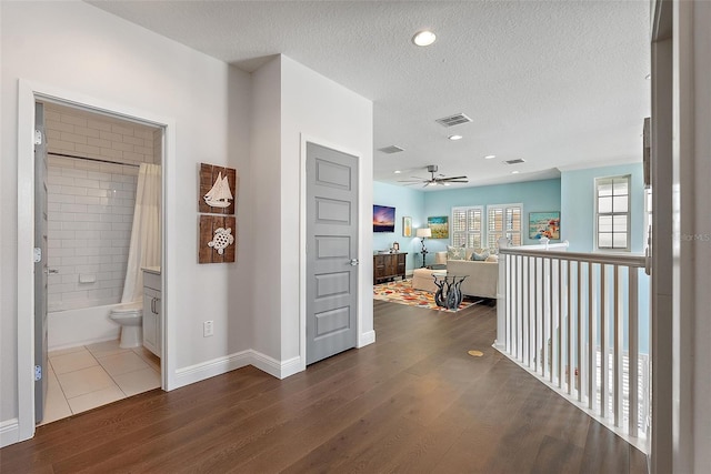 hallway featuring wood-type flooring and a textured ceiling