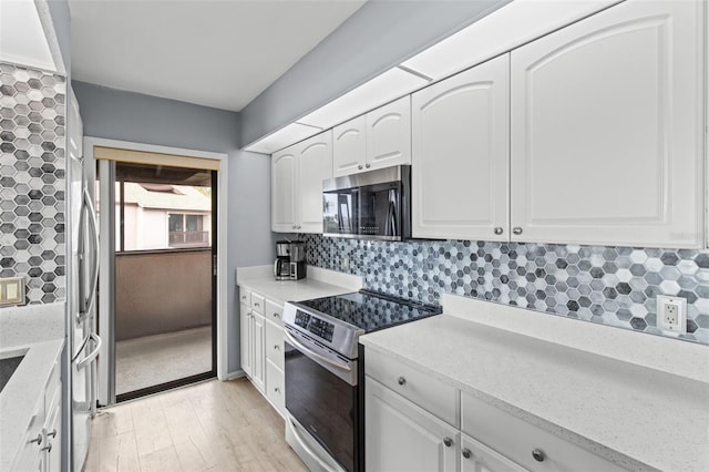 kitchen with light stone counters, light hardwood / wood-style flooring, stainless steel appliances, decorative backsplash, and white cabinets