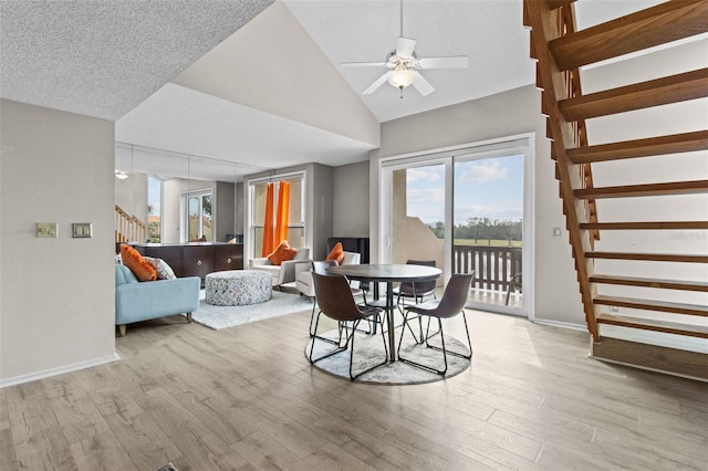 dining space featuring ceiling fan, lofted ceiling, and light hardwood / wood-style flooring