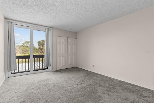 unfurnished bedroom with carpet, access to exterior, a textured ceiling, and a closet