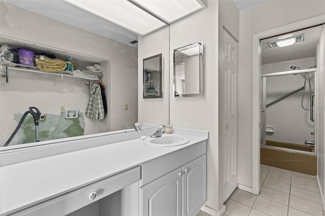 bathroom with tile patterned flooring, vanity, and tiled shower / bath combo