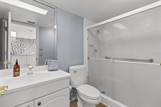 bathroom with walk in shower, vanity, and toilet