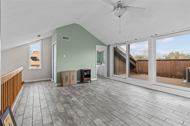 bonus room featuring a textured ceiling, vaulted ceiling, light hardwood / wood-style floors, and ceiling fan