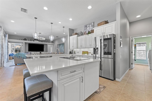 kitchen featuring sink, stainless steel appliances, white cabinets, a kitchen bar, and kitchen peninsula