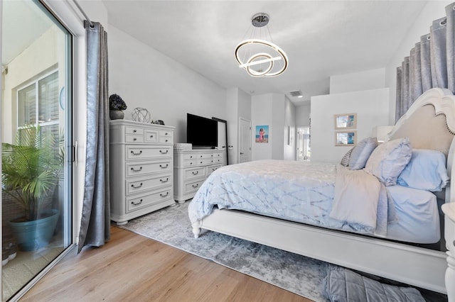 bedroom with a chandelier and light hardwood / wood-style floors