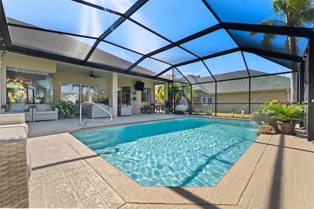 view of swimming pool with ceiling fan, a patio, and glass enclosure