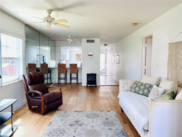 living area with visible vents and light wood-style floors