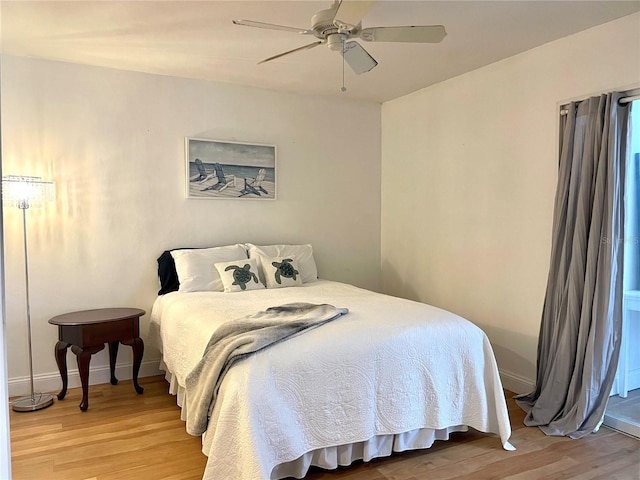 bedroom with a ceiling fan, baseboards, and wood finished floors