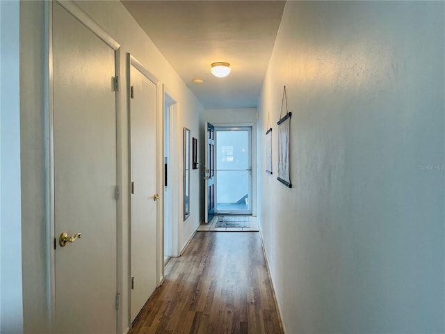 hallway with baseboards and wood finished floors