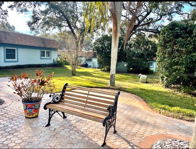 surrounding community with a patio area, a lawn, and an outdoor structure