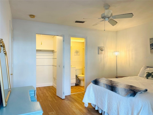 bedroom featuring visible vents, a spacious closet, a ceiling fan, connected bathroom, and light wood-type flooring