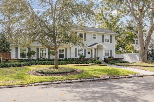 colonial home featuring a front lawn