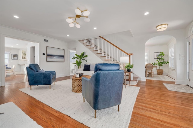 living room featuring a wealth of natural light, light hardwood / wood-style flooring, and ornamental molding