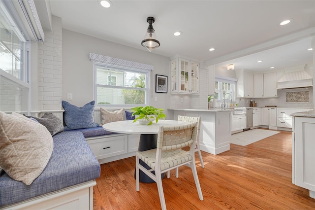 dining area featuring breakfast area, plenty of natural light, sink, and light hardwood / wood-style floors