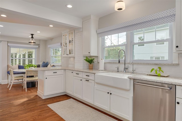 kitchen featuring sink, hardwood / wood-style flooring, dishwasher, white cabinetry, and decorative backsplash