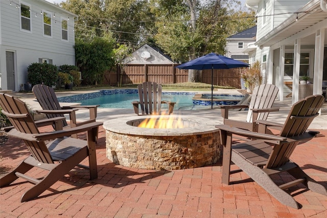 view of swimming pool featuring an in ground hot tub, a patio, and a fire pit