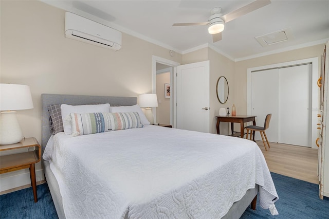 bedroom with crown molding, a closet, a wall unit AC, hardwood / wood-style flooring, and ceiling fan