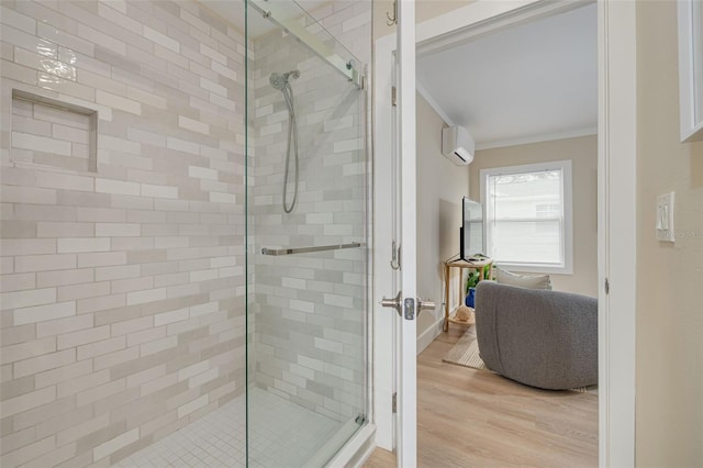 bathroom with ornamental molding, an enclosed shower, wood-type flooring, and a wall mounted air conditioner