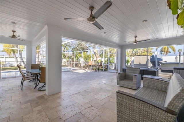 view of patio / terrace featuring outdoor lounge area, ceiling fan, and glass enclosure