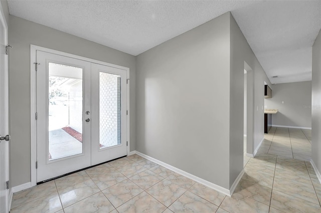 doorway featuring french doors, a textured ceiling, and light tile patterned floors