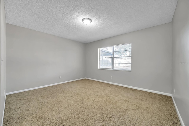 empty room with carpet floors and a textured ceiling