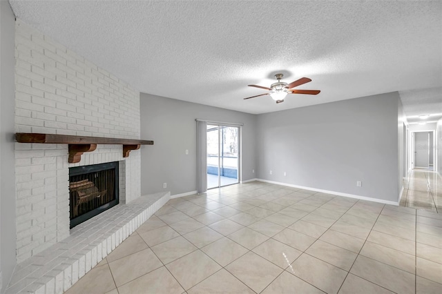 unfurnished living room with a brick fireplace, light tile patterned floors, a textured ceiling, and ceiling fan