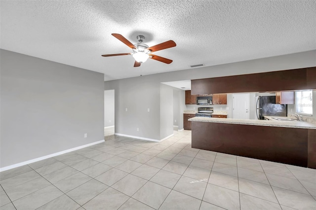 interior space with sink, light tile patterned floors, ceiling fan, stainless steel appliances, and kitchen peninsula