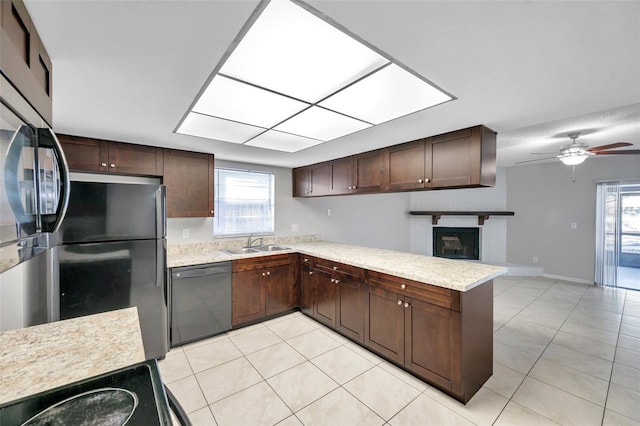 kitchen with black appliances, sink, light tile patterned floors, dark brown cabinetry, and kitchen peninsula