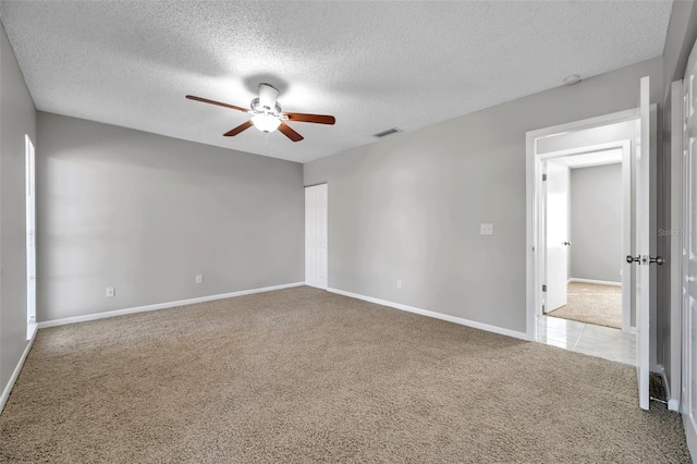 carpeted spare room with ceiling fan and a textured ceiling