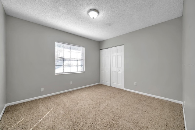 unfurnished bedroom featuring carpet floors, a closet, and a textured ceiling