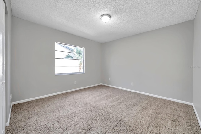 carpeted spare room featuring a textured ceiling